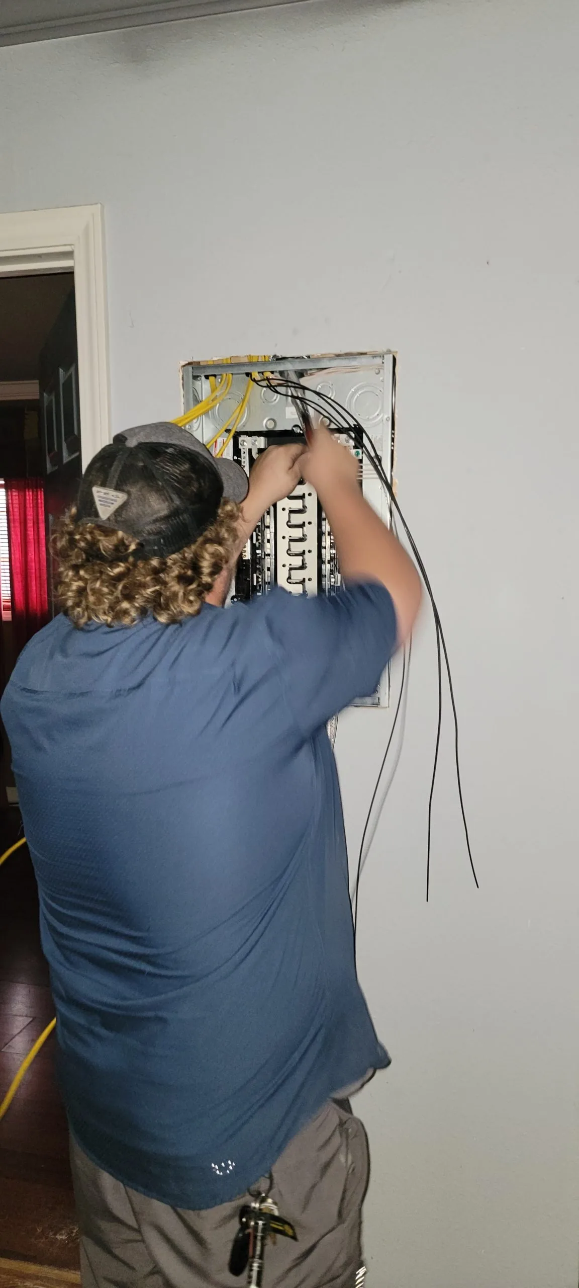 Good Times Electric electrician wiring a breaker panel