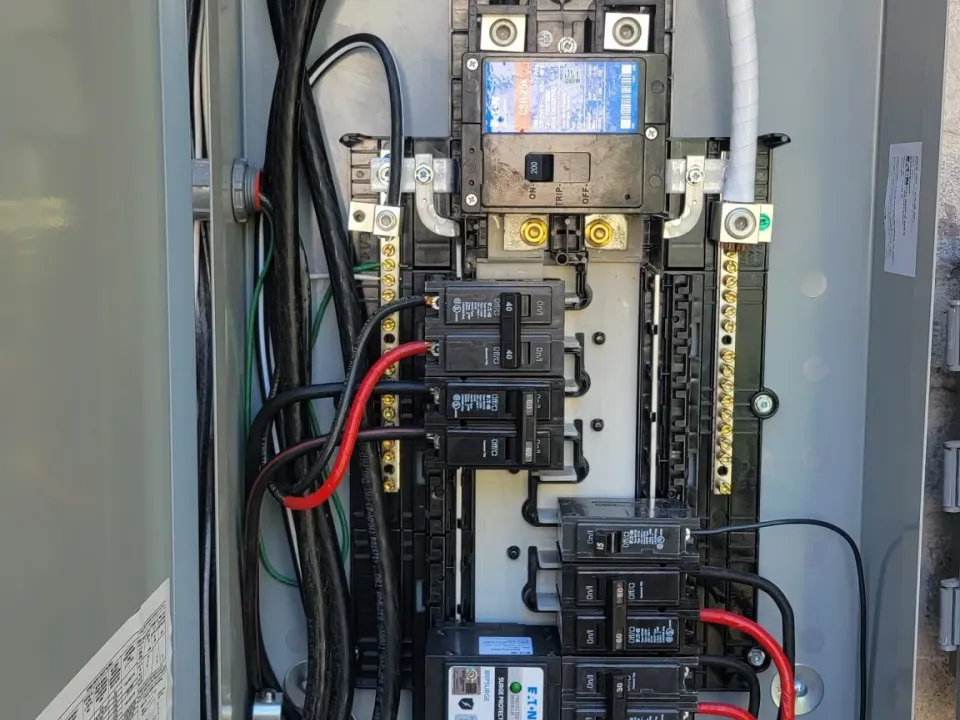 Exterior meter-main electrical panel with breakers installed, cover open