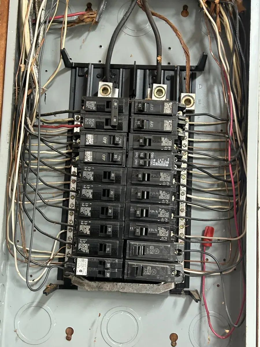 An open breaker panel with its cover off during a breaker replacement