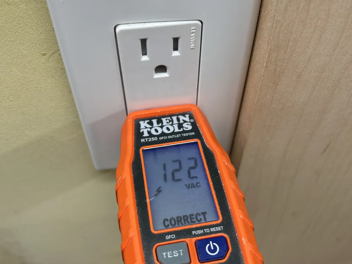 A new outlet with a plug-in tester reading 122 volts and correct wiring